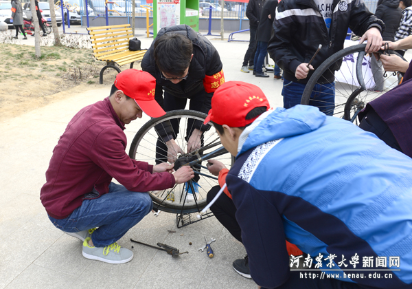 机电雷锋站在家属区帮助居民维修自行车 机电雷锋站在家属区帮助居民维修自行车
