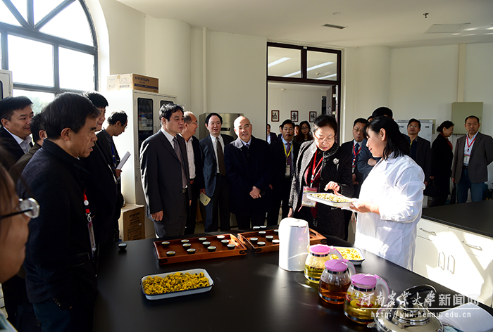 在中药材专业展示平台前,专家们饶有兴致地向师生询问了解花茶制作 在中药材专业展示平台前,专家们饶有兴致地向师生询问了解花茶制作