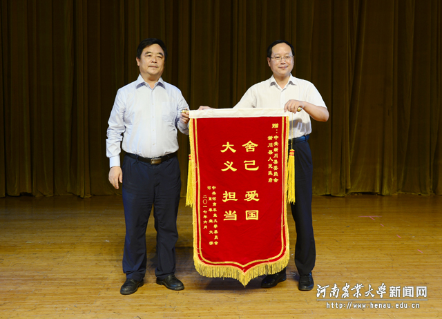 校党委副书记、工会主席褚金海向报告团代表赠送锦旗 校党委副书记、工会主席褚金海向报告团代表赠送锦旗
